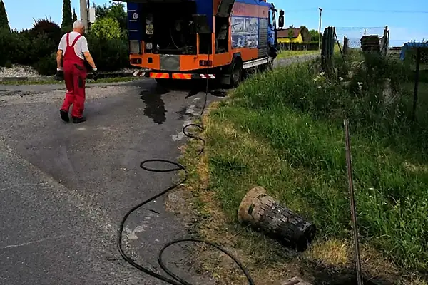 Čištění uliční vpusti tlakovou vodou, hadice vedená od tlakového vozu